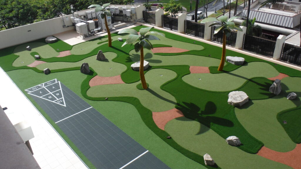 Birdseye view of a 9-hole custom mini golf course and shuffleboard courts on hotel rooftop