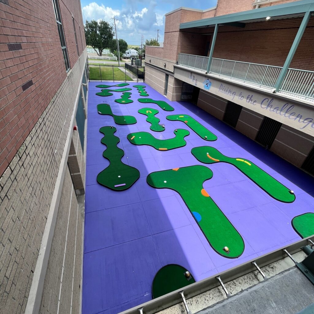 miniature golf course on the roof of a high school, portable course with colorful faux wood shapes