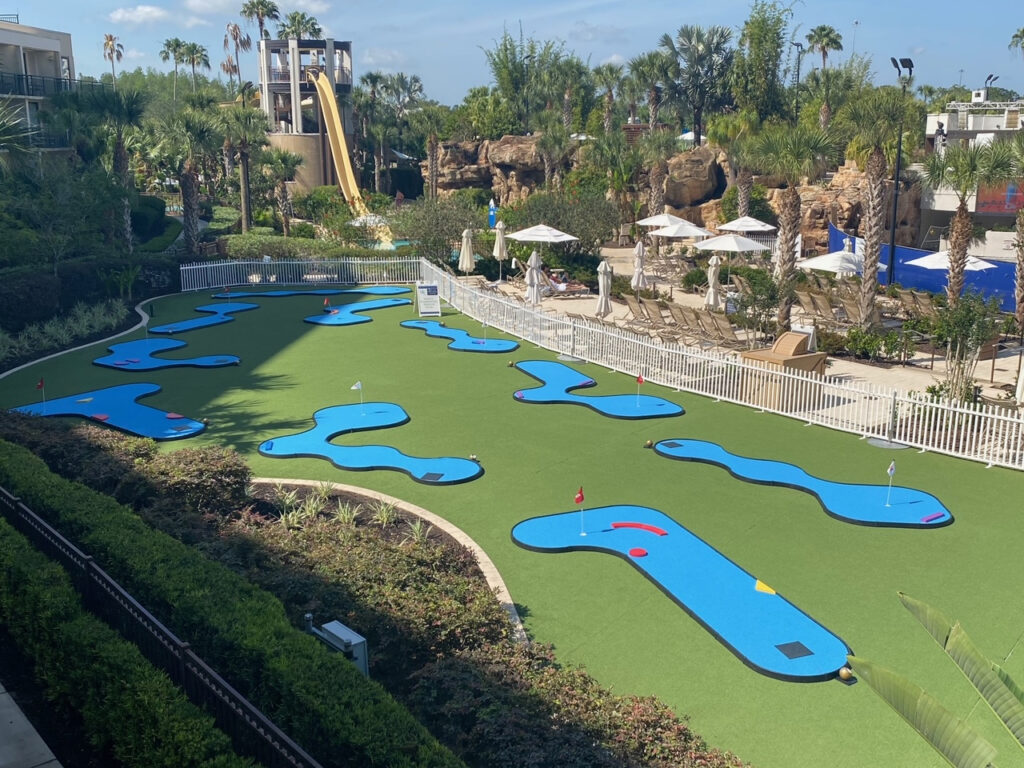 miniature golf course ont he grass at a hotel, portable course with colorful faux wood shapes