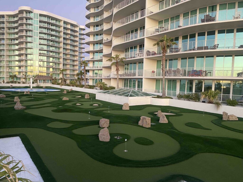 Rooftop miniature golf course, at a resort, with a natural look & feel, resembling a real golf course with bunkers & bumps. 