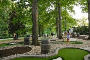 Keswick Vineyard mini golf players admire the tall trees and natural beauty of the 9-hole course