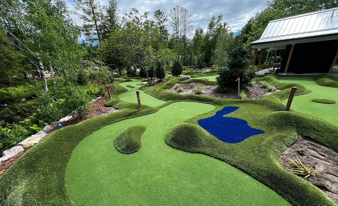 A mini golf course with natural looking terrain, faux sand bunkers and slopes on various levels