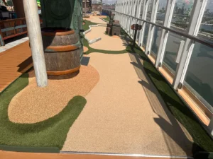 Some faux sand mini-golf holes play alongside the outer railed edge of the Icon of the Seas.