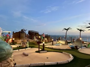 Fiber optic lights on 3-foot poles brighten the mini-golf course for these players at dusk.