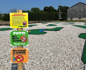 Signs by the first mini-golf course hole at the Pinetree Campground and RV Resort list course rules